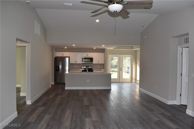 Unfurnished living room featuring baseboards, visible vents, dark wood-type flooring, and french doors