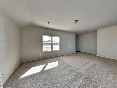 Carpeted empty room with vaulted ceiling and baseb