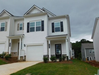 View of front of home featuring an attached garage, a front lawn, and concrete driveway
