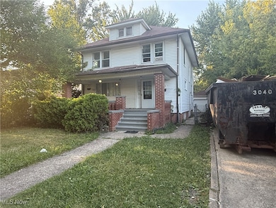 American foursquare style home featuring a porch, a front lawn, and a gate
