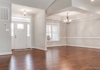 Foyer entrance featuring a chandelier, dark hardwo