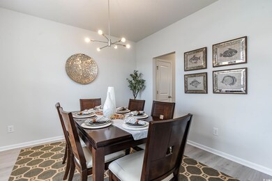 Dining space with a chandelier, wood finished floors, and lofted ceiling
