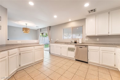 Kitchen featuring white cabinets, dishwasher, hanging light fixtures, light tile patterned floors, and recessed lighting