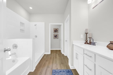 Bathroom with vanity, a tile shower, a bath, and light wood-style flooring