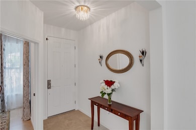 Foyer entrance with a chandelier and light tile patterned flooring