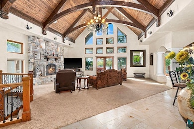 Living room featuring decorative columns, stone fi