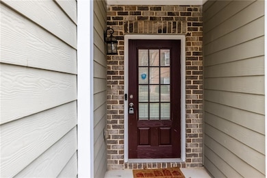 Doorway to property featuring brick siding