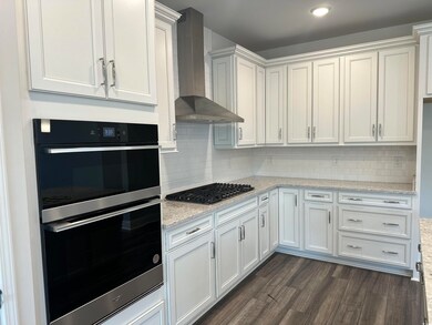 Kitchen featuring gas cooktop, white cabinetry, wa
