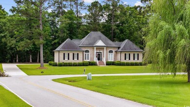 View of front facade featuring a front yard, brick siding, and view of scattered trees
