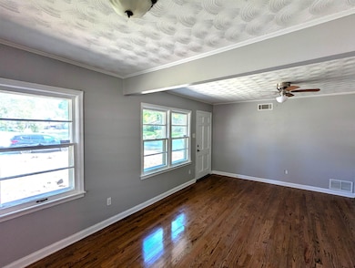 Spare room with ceiling fan, baseboards, dark wood