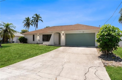 Ranch-style house with a garage, stucco siding, a front yard, and concrete driveway