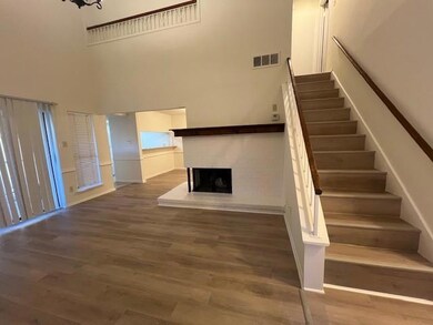 Staircase with a high ceiling, a brick fireplace, 