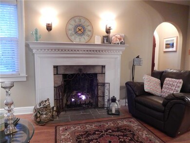 Stone hearth fireplace has white trim and dentil c