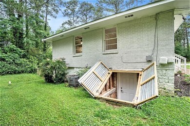 Rear view of property with brick siding, central air condition unit, and a yard