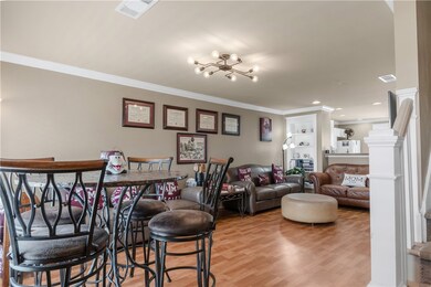 Living room featuring crown molding, light wood-st