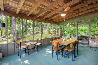 Sunroom / solarium with a ceiling fan, outdoor dining space, plenty of natural light, and beam ceiling