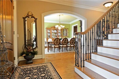 The spacious foyer leads to the formal dining and living rooms through arched doorways with exquisite custom molding.
