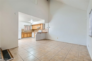 Kitchen featuring white appliances, high vaulted c