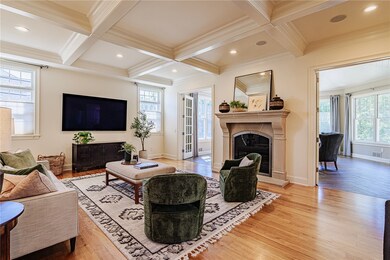 Stunning coffered ceiling living room has significant light and a wood burning fireplace--just take in how bright and elegant this space is the benefit of 10-foot ceilings.
