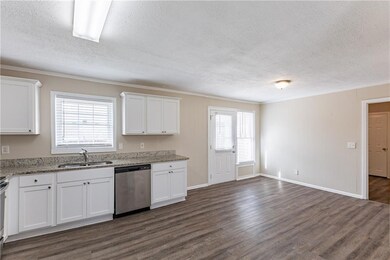Kitchen featuring sink, dishwasher, white cabinetr
