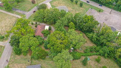 Richmond Hill Dr is to the left and Ewing at the top of this photo. The property line closely follows the tree line as seen here.
