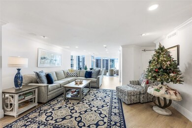 Living room with light wood-type flooring and ornamental molding