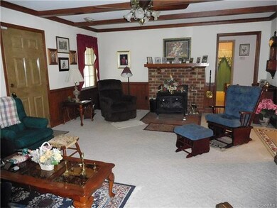 Family room has beam ceiling, brick fireplace with