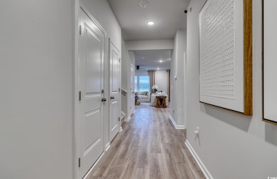 Corridor featuring light wood finished floors and baseboards