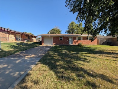 Ranch-style house with concrete driveway, brick siding, and a garage