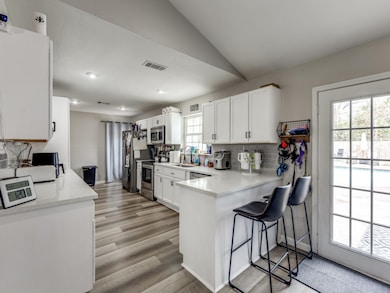 Bright, modern kitchen with white cabinetry, stain