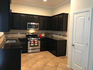 Nice kitchen with espresso cabinetry complimented by granite counters with tumbled marble backsplash with mosaic inserts.