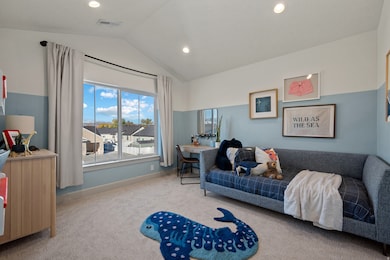 Carpeted bedroom with lofted ceiling and recessed lighting