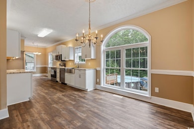 Kitchen featuring a chandelier, appliances with st