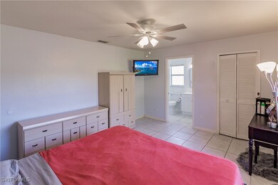 Tiled bedroom with ensuite bath and ceiling fan