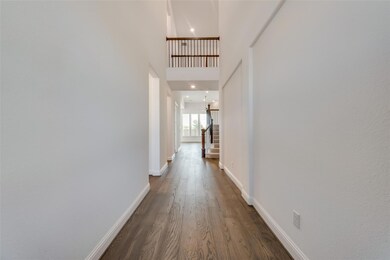 Corridor with a towering ceiling and dark hardwood