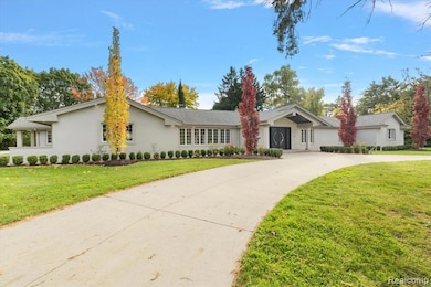 View of front of house with a front yard, curved driveway, and stucco siding