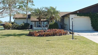 Ranch-style home featuring a garage and a front ya