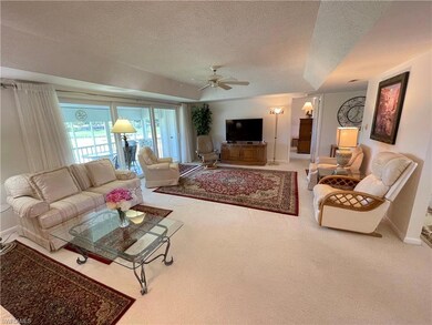 Living room featuring carpet, ceiling fan, and a t