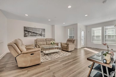 Living area with recessed lighting and light wood-style floors