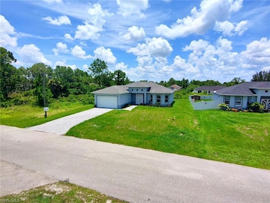 View of front facade with driveway, a garage, and a front lawn
