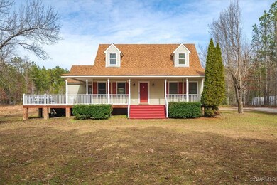 New england style home with a front yard and a por