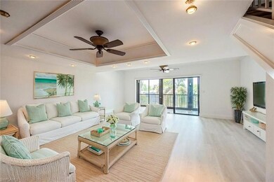Living area with a raised ceiling, a ceiling fan, light wood-type flooring, and ornamental molding