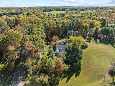 Aerial view of property and surrounding area with a forest