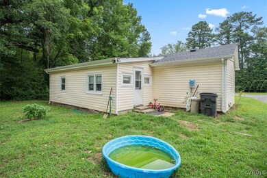 Back of property featuring a lawn and a shingled r