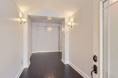 Corridor featuring baseboards, a notable chandeli