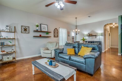 Living room featuring arched walkways, baseboards
