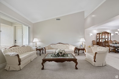 Formal living / dining rooms featuring crown molding, carpet & tile flooring, and high vaulted ceiling, three-tone paint, vaulted ceilings and recessed lighting