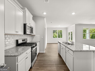 Aria kitchen with stone countertops and white subway tile backsplash