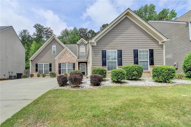 View of front of house with brick siding, a front yard, cooling unit, and concrete driveway
