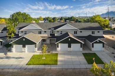 View of front of house with stone siding, driveway, and a mountain view